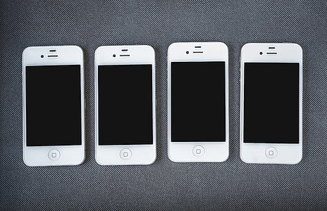 four white 4 iPhone 4's on gray textile thumbnail
