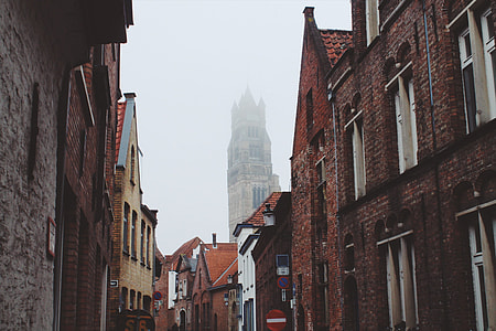 low-angle photography of brown concrete buildings during foggy day thumbnail