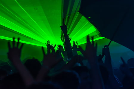 silhouette photography of people raising hands with green light thumbnail
