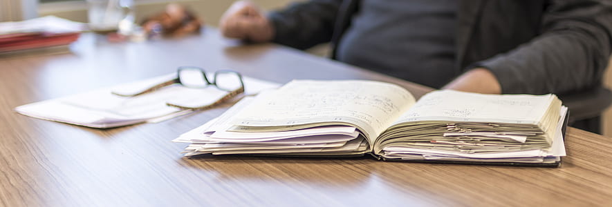 white book on brown wooden table thumbnail