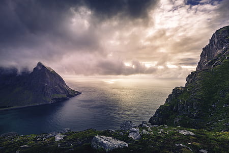 aerial photography of mountains near ocean under cloudy sky thumbnail