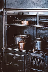 brown samovar pot near gold-colored kettle on oven inside room thumbnail