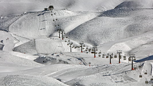 cable cars above snow-covered field during daytime thumbnail