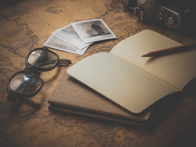 vignette photography of pencil on memo pad beside instant camera photos and eyeglasses thumbnail