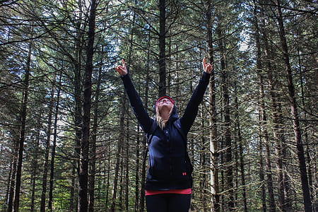 woman standing near tree while raising her hands thumbnail