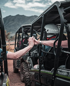 two person holding hands while riding dune buggy thumbnail