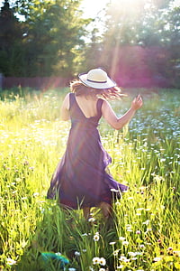 woman in purple sleeveless dress standing on bed of flowers thumbnail