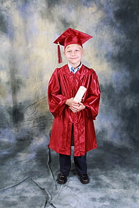 boy in red academic gown holding diploma while standing thumbnail