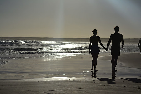 silhouette photography of man and woman near sea thumbnail