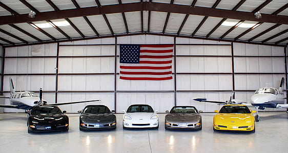 five cars parked near two planes thumbnail