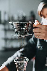 person holding coffee strainer indoor thumbnail
