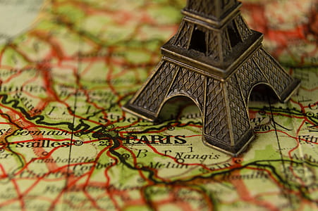 closeup photography of Eiffel tower miniature on Paris map thumbnail