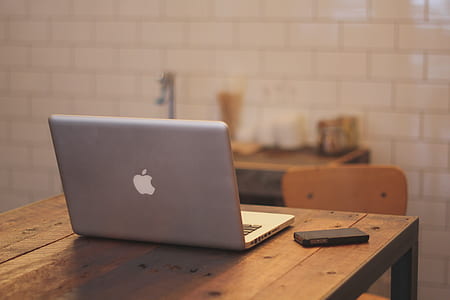 silver MacBook on brown table thumbnail