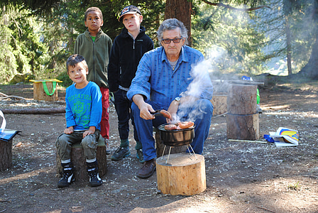 man sitting on wood slab holding grilled food thumbnail