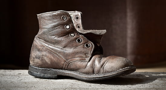 unpaired brown leather boot on grey concrete surface thumbnail