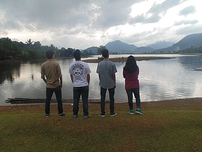 men and woman standing near body of water thumbnail
