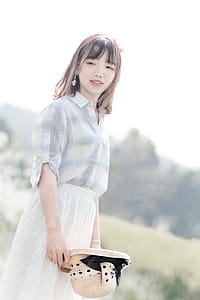 Photography of Woman Holding Straw Hat thumbnail