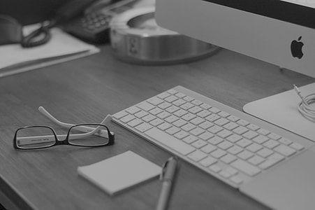 selective focus photography of black framed eyeglasses near white Apple magic keyboard thumbnail