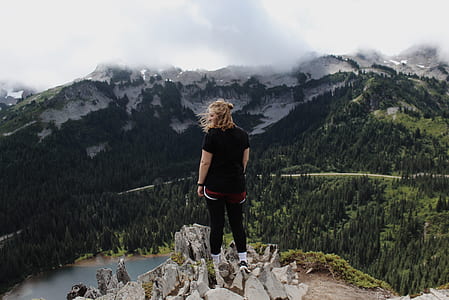person at the top of cliff facing mountain thumbnail