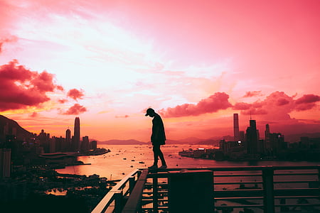 silhouette of man standing on fence thumbnail
