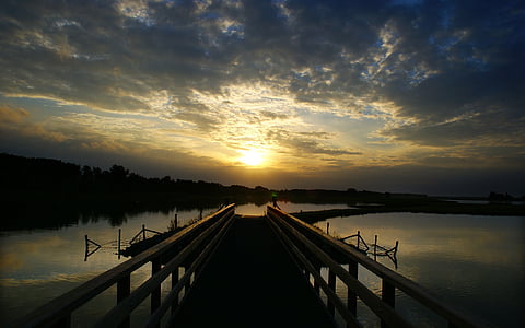 pier on body of water facing sunshine thumbnail