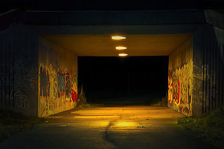 grey concrete tunnel turned on light with wall graffiti at nightie thumbnail