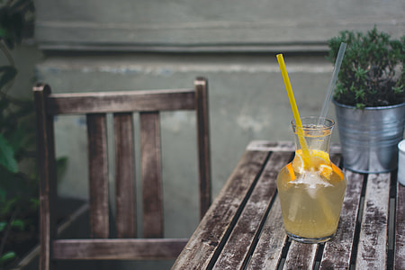 Orange lemonade at a wooden desk outside thumbnail