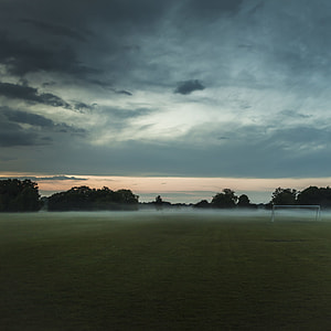 grass field under cloudy sky thumbnail