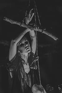 grayscale photography of woman holding wood with rope thumbnail