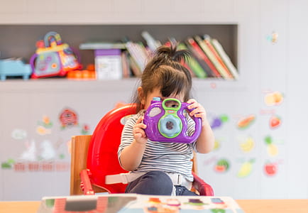 girl holding purple camera toy thumbnail