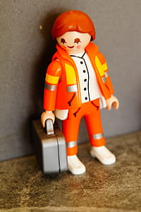 human in orange suit toy thumbnail