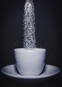 pouring sugar on white ceramic cup with saucer thumbnail