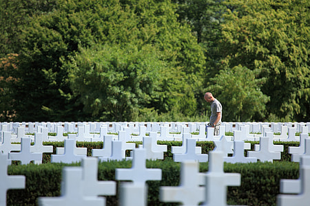man standing at cemetery surrounded by grave thumbnail