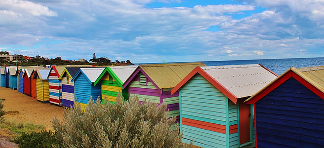 assorted-colored wooden house under white clouds thumbnail