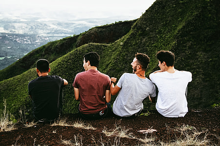 four men sitting on mountain cliff thumbnail