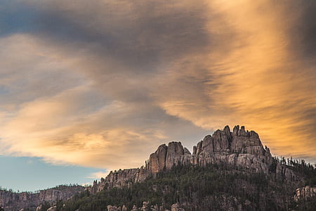 low angle photography of rock formation near forest thumbnail