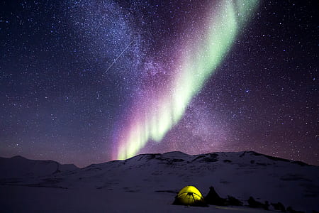 tents on snow covered terrain with purple aurora thumbnail