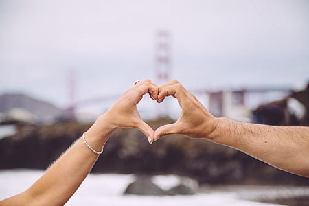 two people doing heart hand sign in front of golden gate bridge during daytime shallow focus photography thumbnail