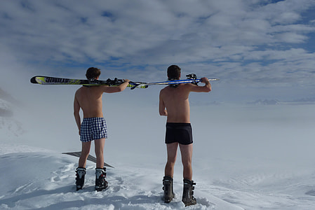 two man standing on top of mountain covered with snow carrying skis under cloudy sky during daytime thumbnail