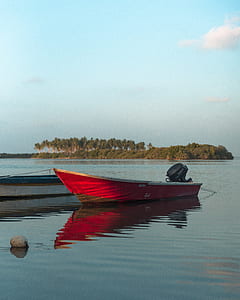 red motorboat on water near island thumbnail