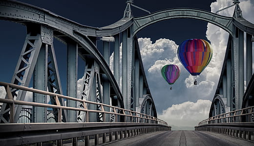 two multicolored hot air balloons near bridge thumbnail