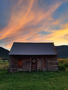 brown and gray roofed house under yellow and blue sky thumbnail