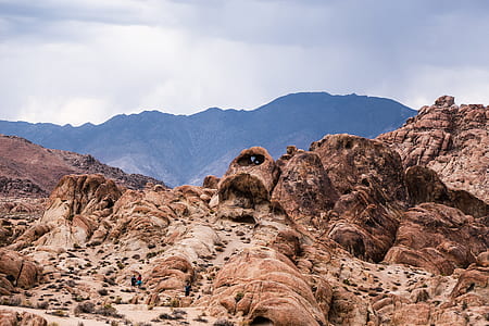 landscape photo of brown rock formations under cloudy sky thumbnail