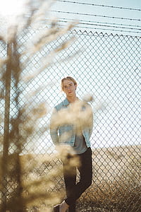 shallow focus photography of man lean back on the fence on his photo shoot thumbnail