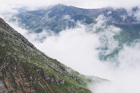 green mountains surrounded by fogs at daytime thumbnail