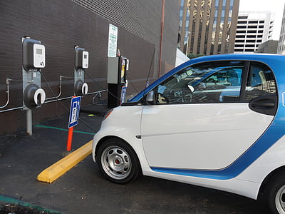 blue and white Smart ForTwo subcompact car charging at vehicle charging station during daytime thumbnail