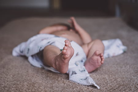 Baby Lying on Brown Surface thumbnail
