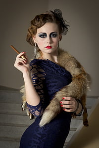 woman wearing blue long-sleeved body-con dress holding tobacco thumbnail