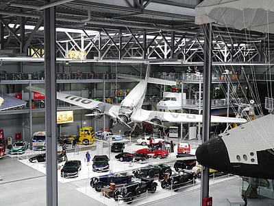 classic white and gray plane and cars inside building thumbnail