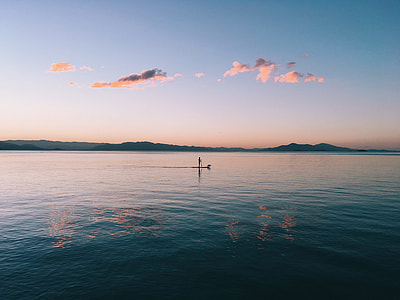 person riding paddleboard on the body of water thumbnail